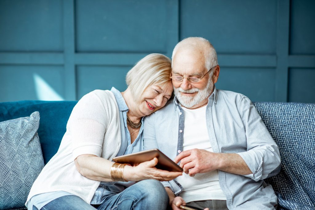 using digital tablet while sitting together on the comfortable couch at home