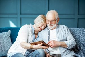 using digital tablet while sitting together on the comfortable couch at home